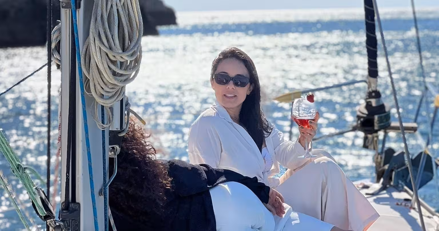 Guests relaxing on a Lagos yacht cruise, sipping cocktails on deck with sparkling Atlantic sea views