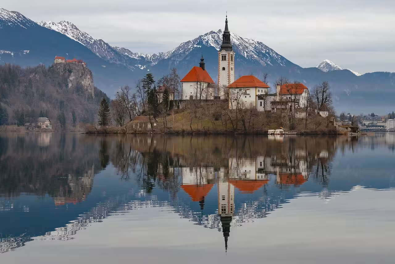Lake Bled island church and castle reflected on calm water, scenic Slovenia day trip from Ljubljana