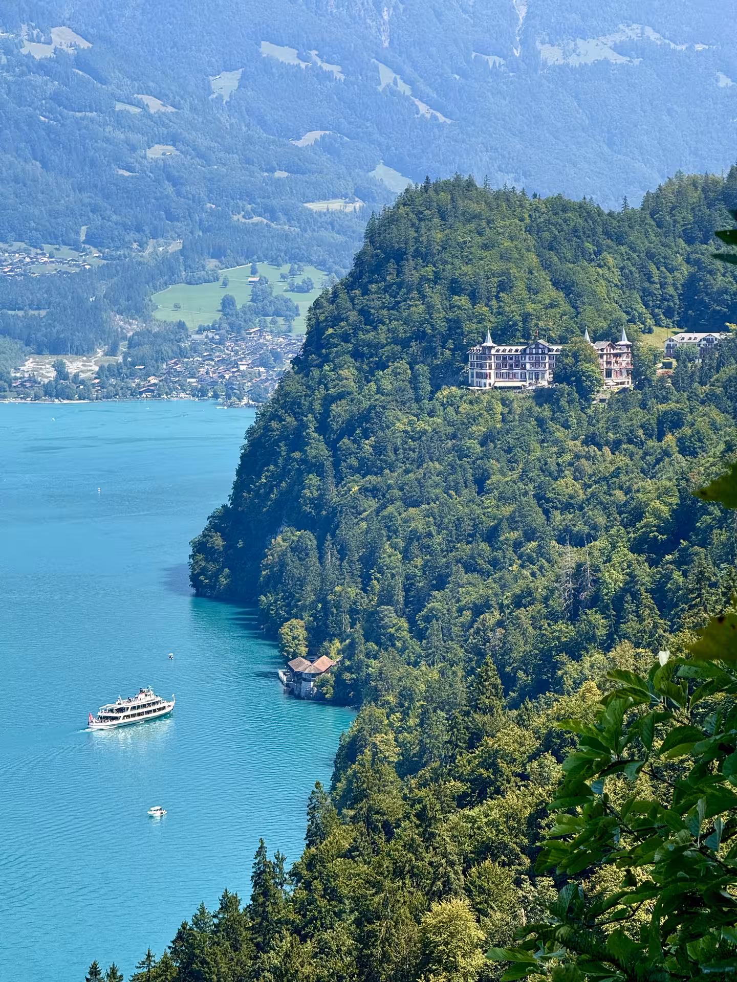 Lake Brienz panorama with boat and forested cliffs, classic view on Iseltwald & Giessbach e-bike tour