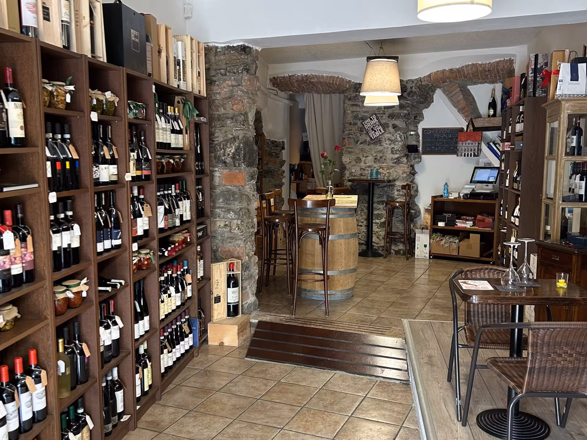 Charming Lake Como wine shop interior with rustic stone walls, ideal for wine tasting and food pairing events.