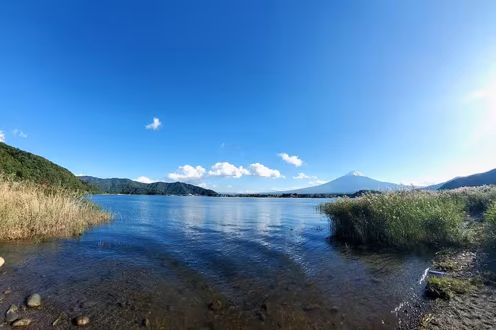 Tranquil Lake Kawaguchi with Mount Fuji in the distance under clear skies, part of the guided 2-day tour itinerary.