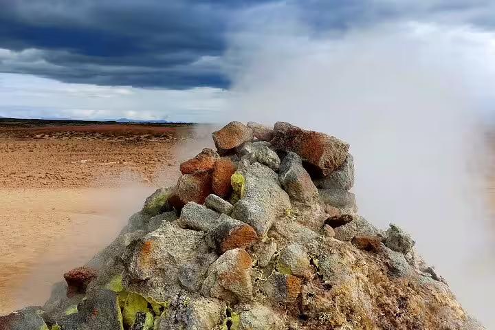 Steaming geothermal fumarole with colorful volcanic rocks at Lake Myvatn, Iceland