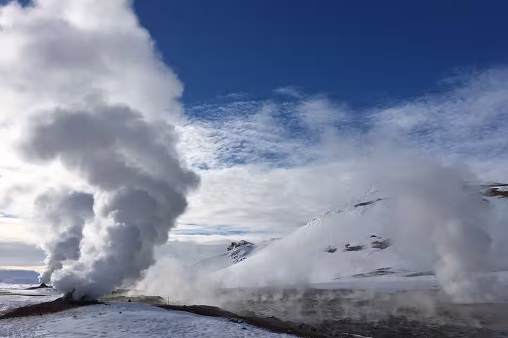 Steam rising from geothermal activity against a snowy landscape near Lake Myvatn in Iceland.