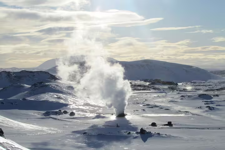 Geothermal steam rising over snow-covered Lake Myvatn volcanic landscape in winter, Iceland
