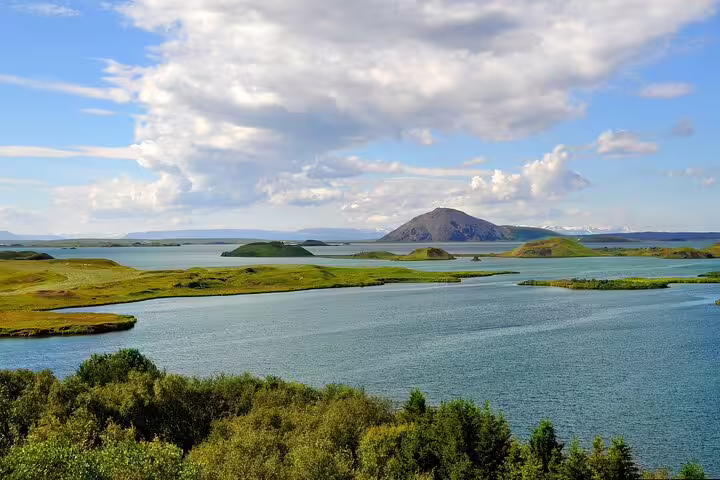 Scenic Lake Mývatn with green volcanic islands and mountain backdrop in North Iceland