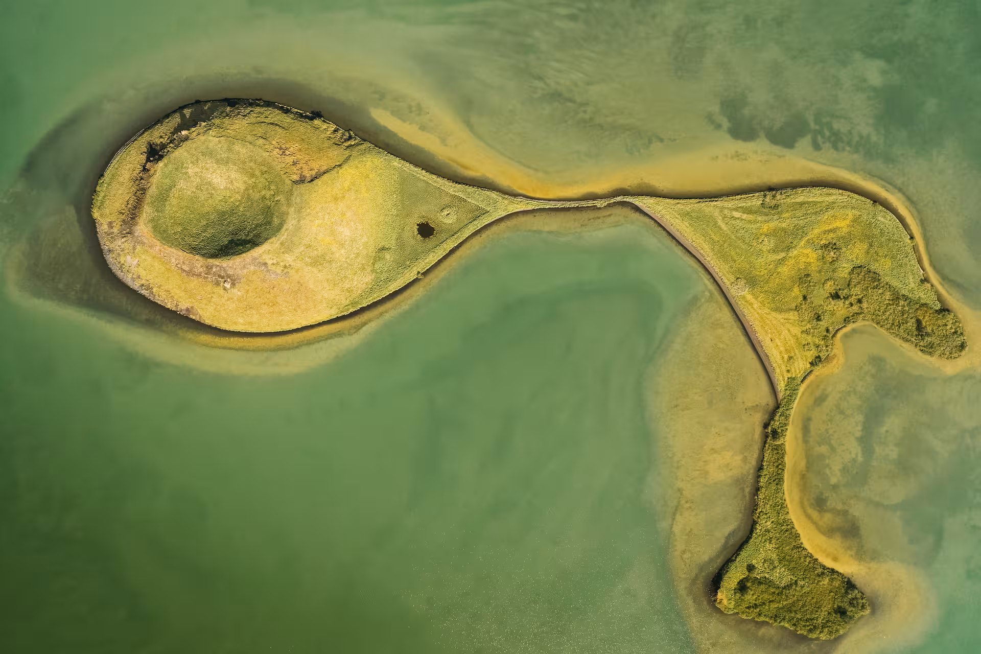 Aerial view of Lake Mývatn’s green volcanic islet and lagoon, a highlight on the Akureyri shore excursion