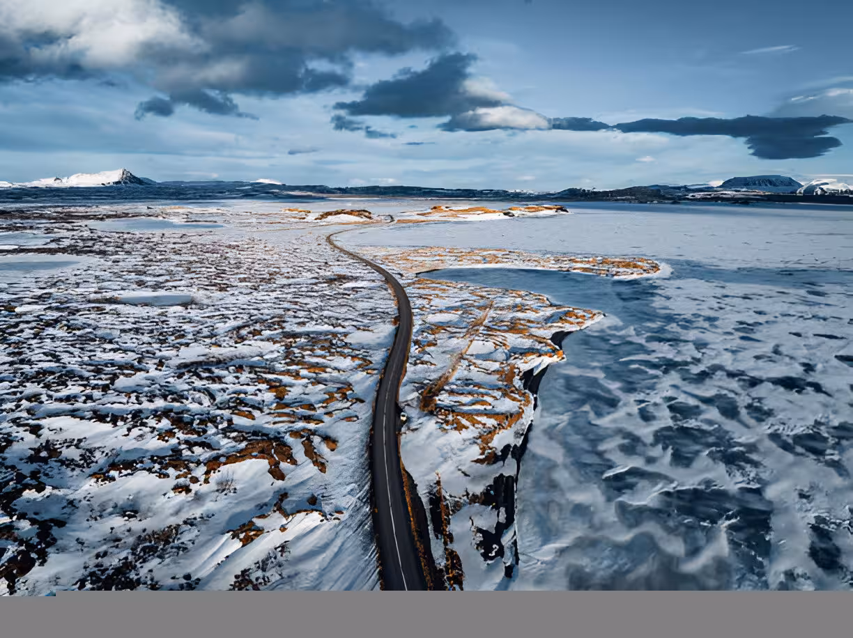 Aerial view of winding road through snow-covered lava fields near Lake Myvatn, Iceland in winter