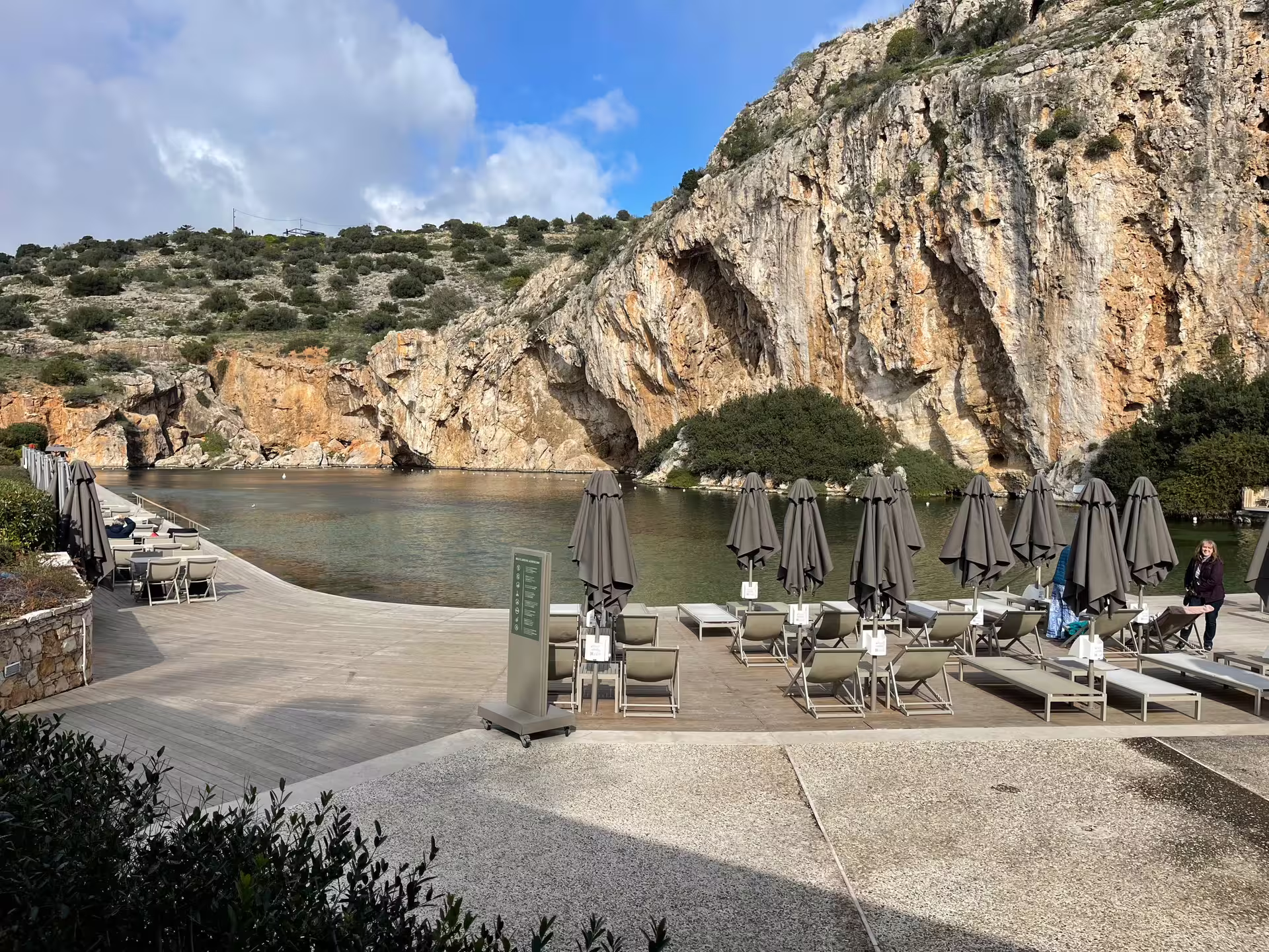 Lake Vouliagmeni cliffs and sunbeds, stop on private Athens panorama tour to Cape Sounio Riviera