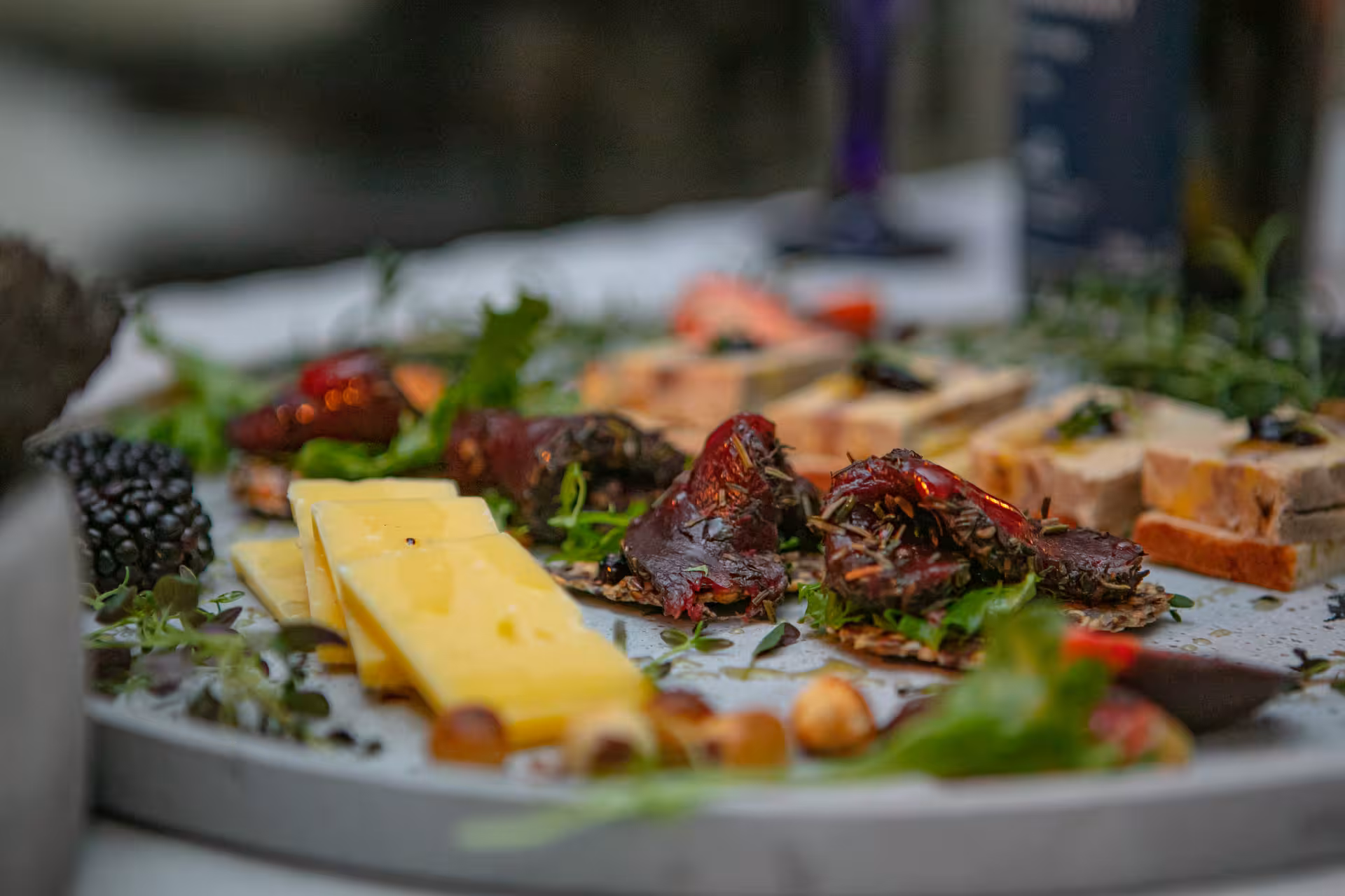 Artisan charcuterie and cheese board with fresh herbs and berries served during a scenic lakeside wine pairing tour
