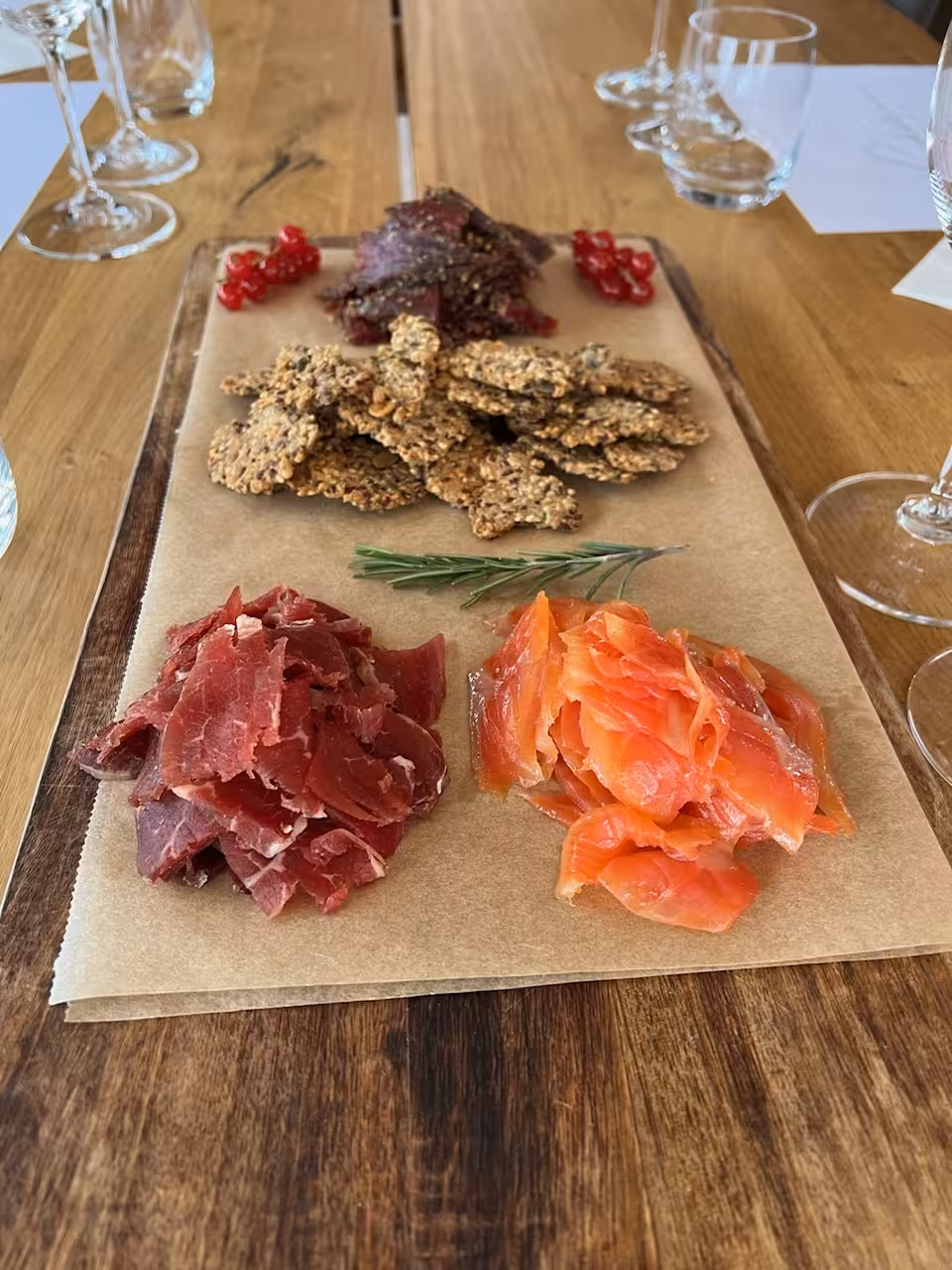 Artisan charcuterie board with cured meat, smoked salmon, seed crackers, and redcurrants for lakeside wine pairing experience