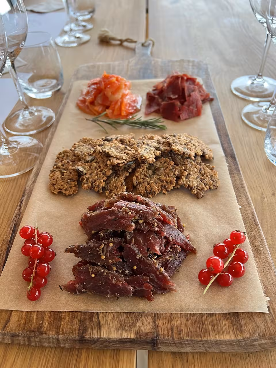 Artisan food pairing board with cured meats, smoked salmon, crackers, and red currants for a lakeside wine tour
