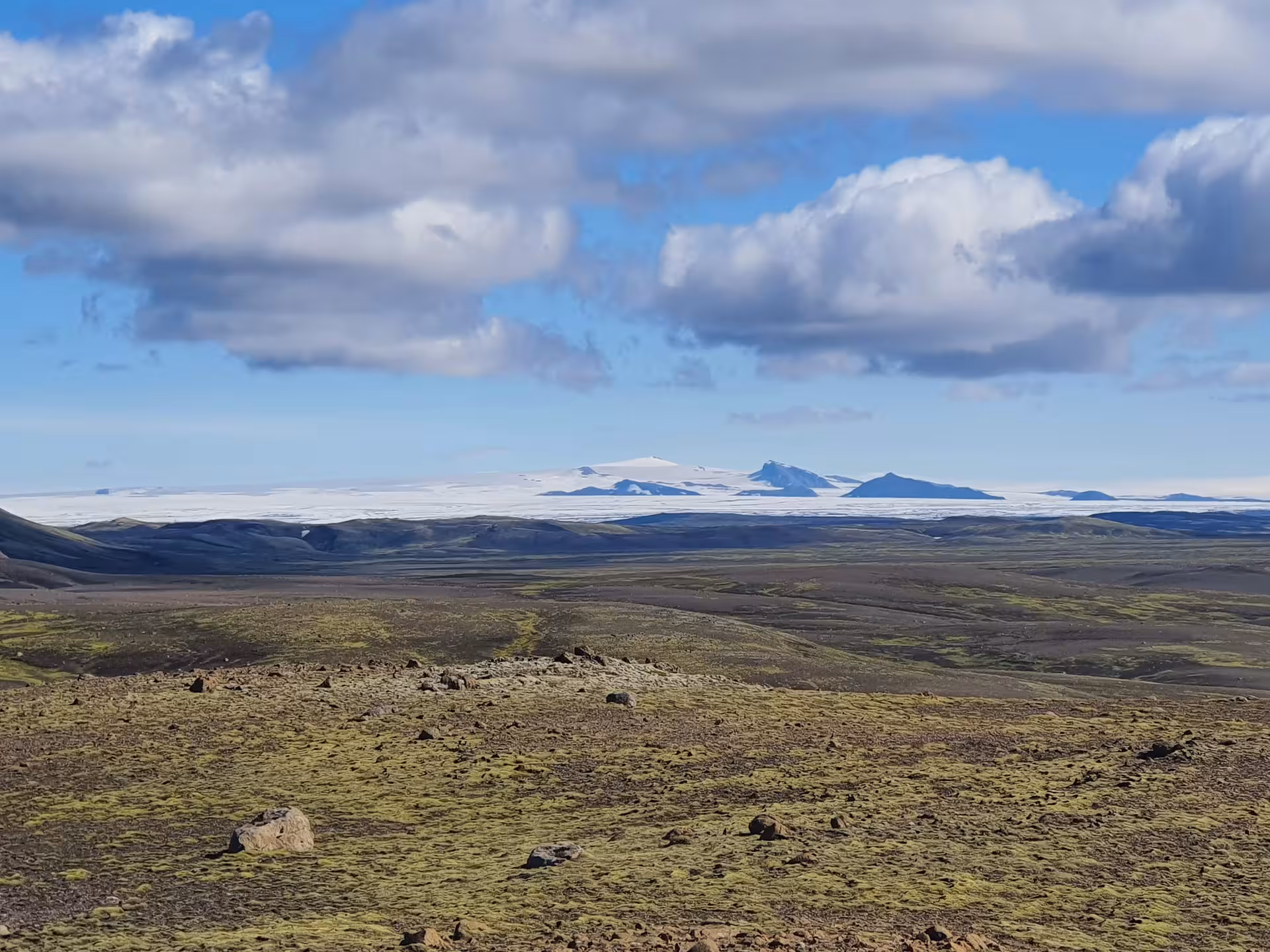 Vast lava field with moss and distant glacier view on Laki Crater Super Jeep tour, South Iceland