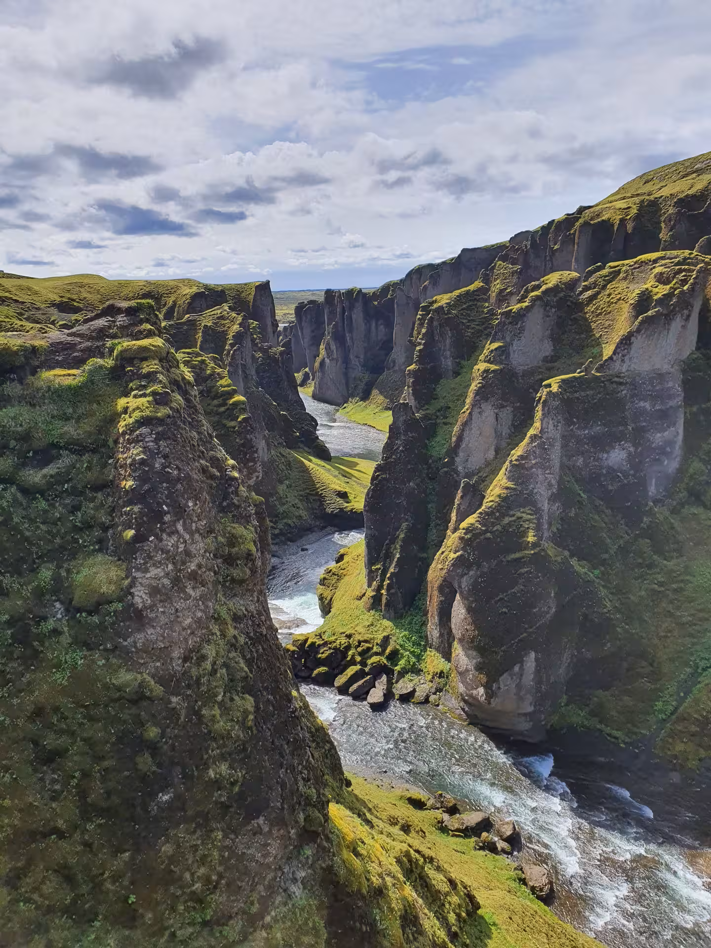 Moss-covered canyon walls with river flowing through Fjaðrárgljúfur canyon in South Iceland