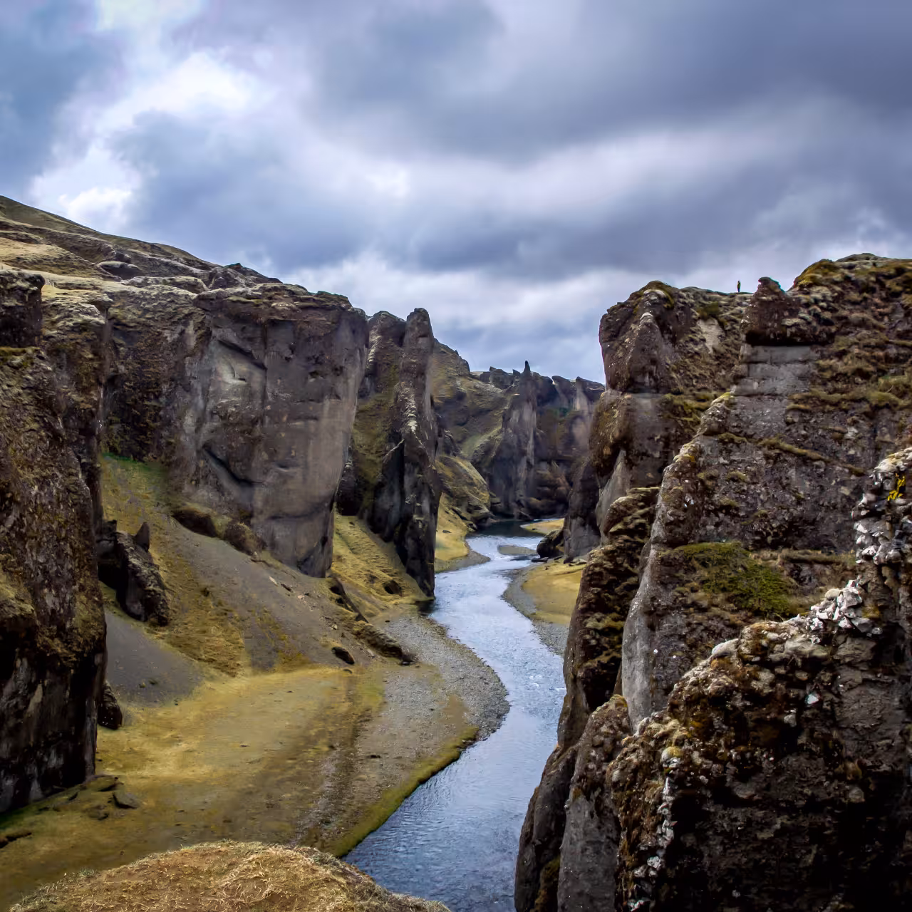 Dramatic Icelandic canyon with winding river and rugged volcanic rock walls on Laki Craters Super Jeep tour from Vik