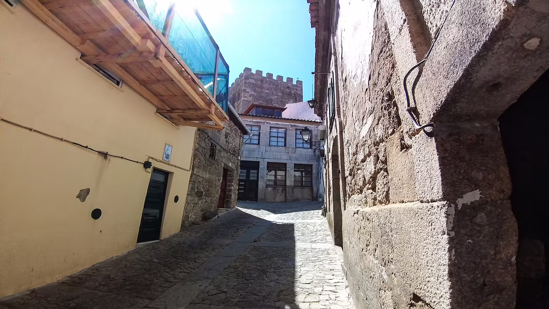 Narrow cobblestone street in Lamego, Portugal, showcasing historic architecture and sunny skies on a private Dão wine region tour.