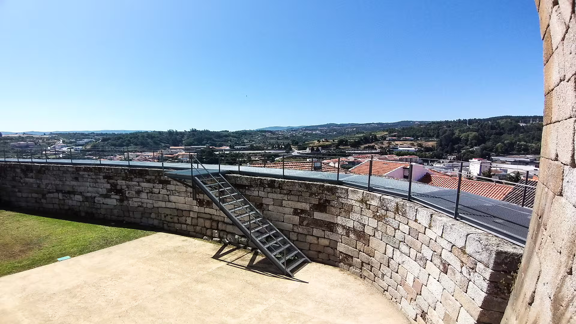 Panoramic view from a historic stone castle wall in Lamego, showcasing the picturesque Dão wine region landscape and clear skies.