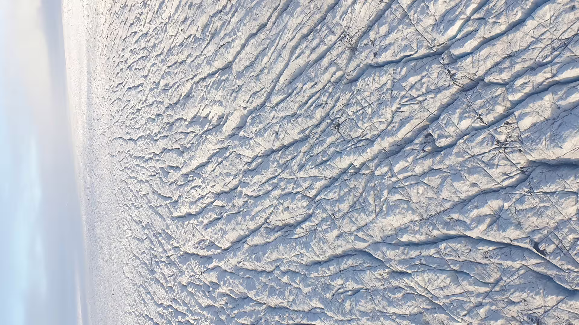 Aerial view of glacier crevasses and snowfields over Landmannalaugar Iceland from airplane