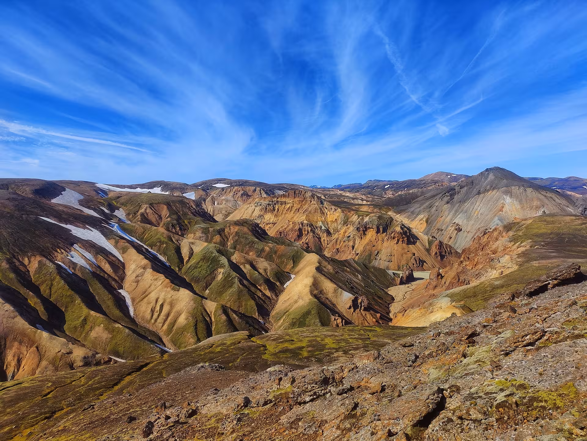 Colorful rhyolite mountains and snow patches at Landmannalaugar highlands Iceland under blue sky