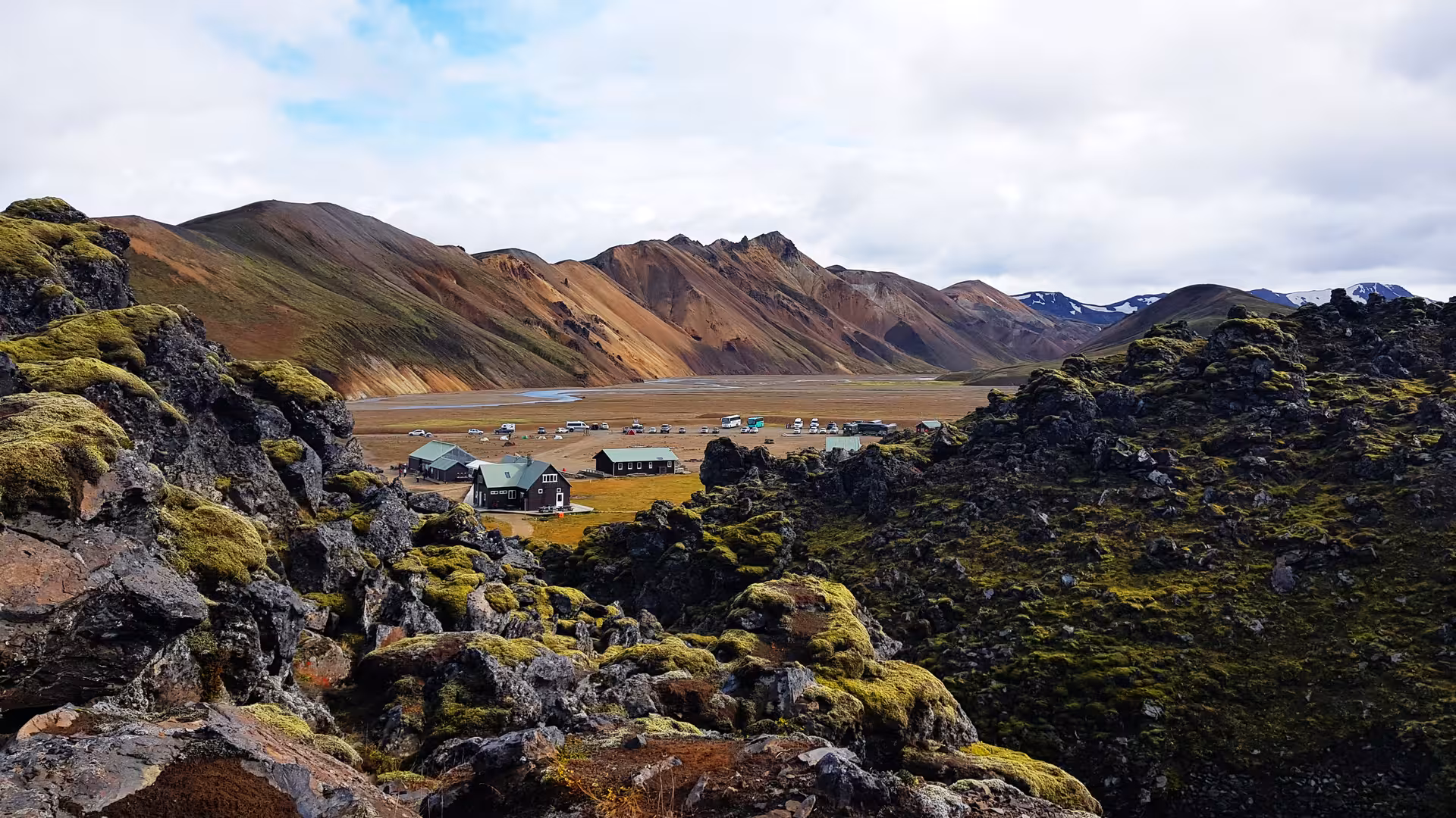 Landmannalaugar highland camp surrounded by colorful rhyolite mountains and mossy lava fields in Iceland