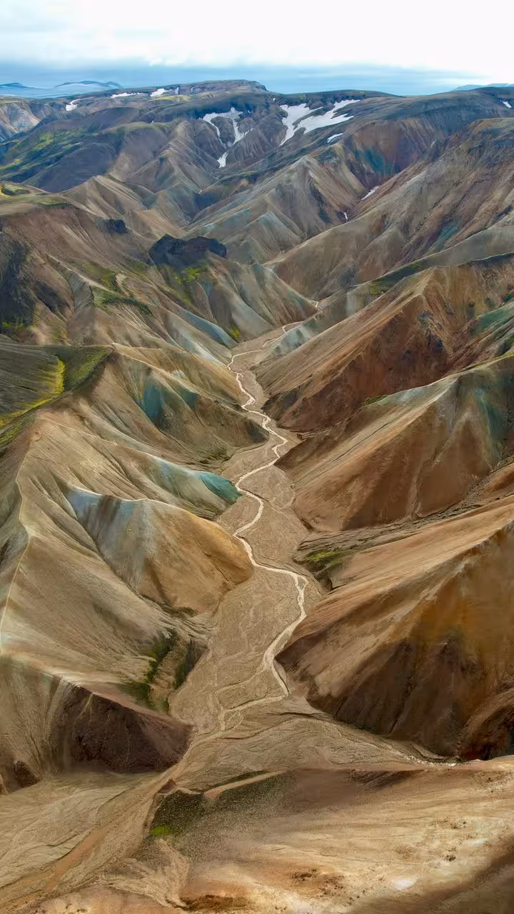 Aerial view of colorful rhyolite mountains and winding river valley in Landmannalaugar highlands, Iceland