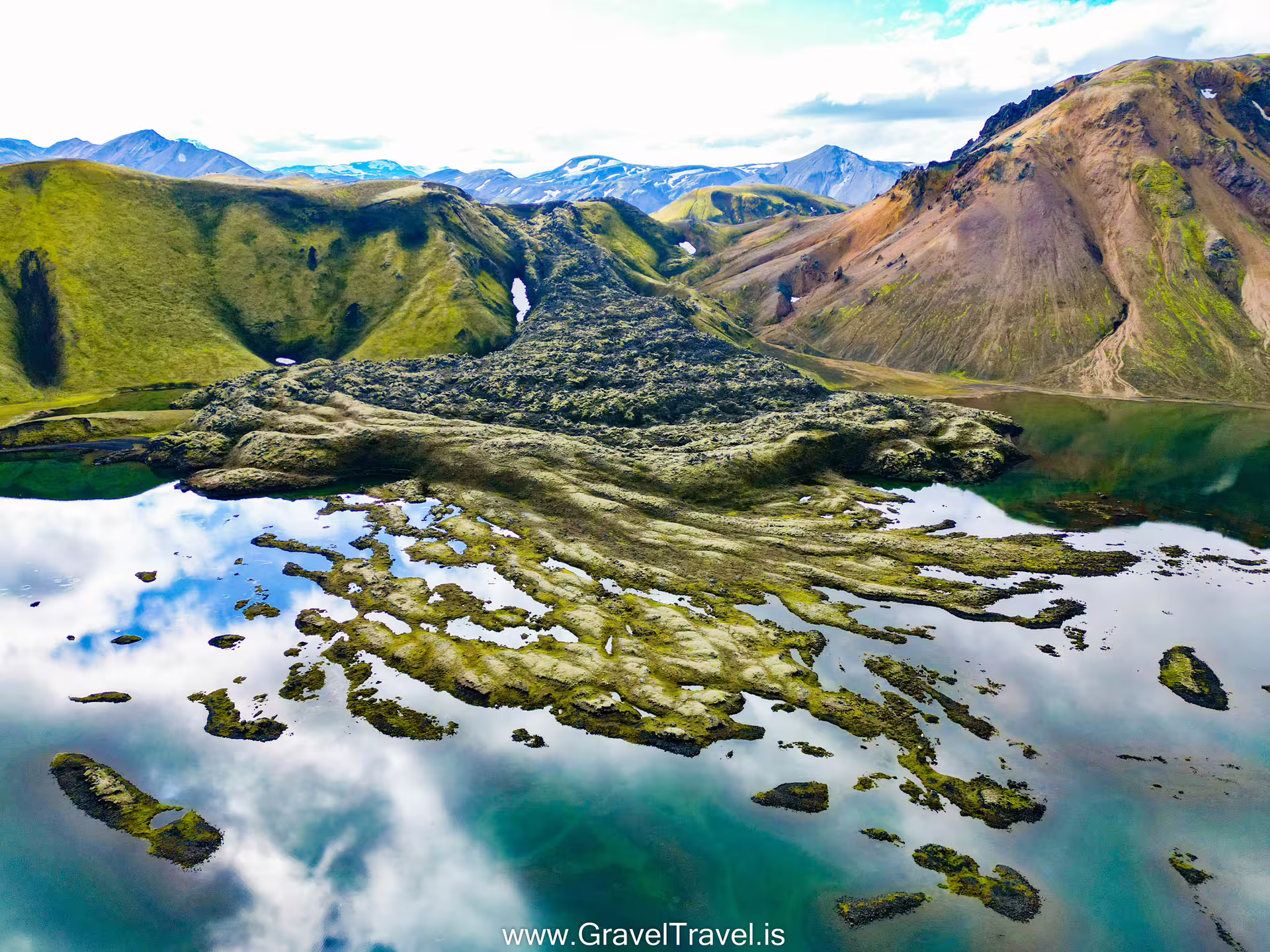 Aerial view of Landmannalaugar Iceland highlands with lava fields reflected in a crystal-clear mountain lake during a private super jeep day trip.