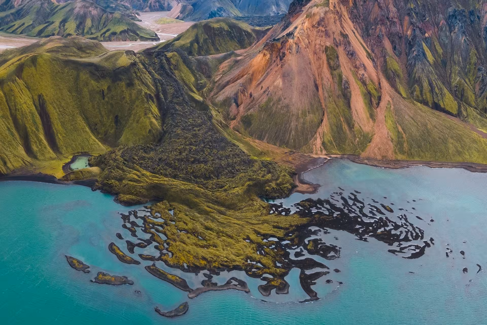 Aerial view of Landmannalaugar highlands with colorful rhyolite mountains and turquoise glacial lake