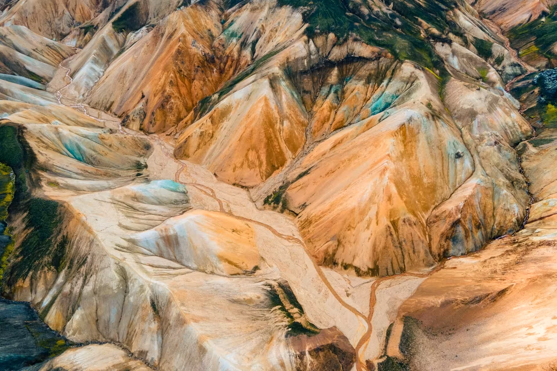 Aerial view of colorful rhyolite mountains in Landmannalaugar highlands with winding stream valleys