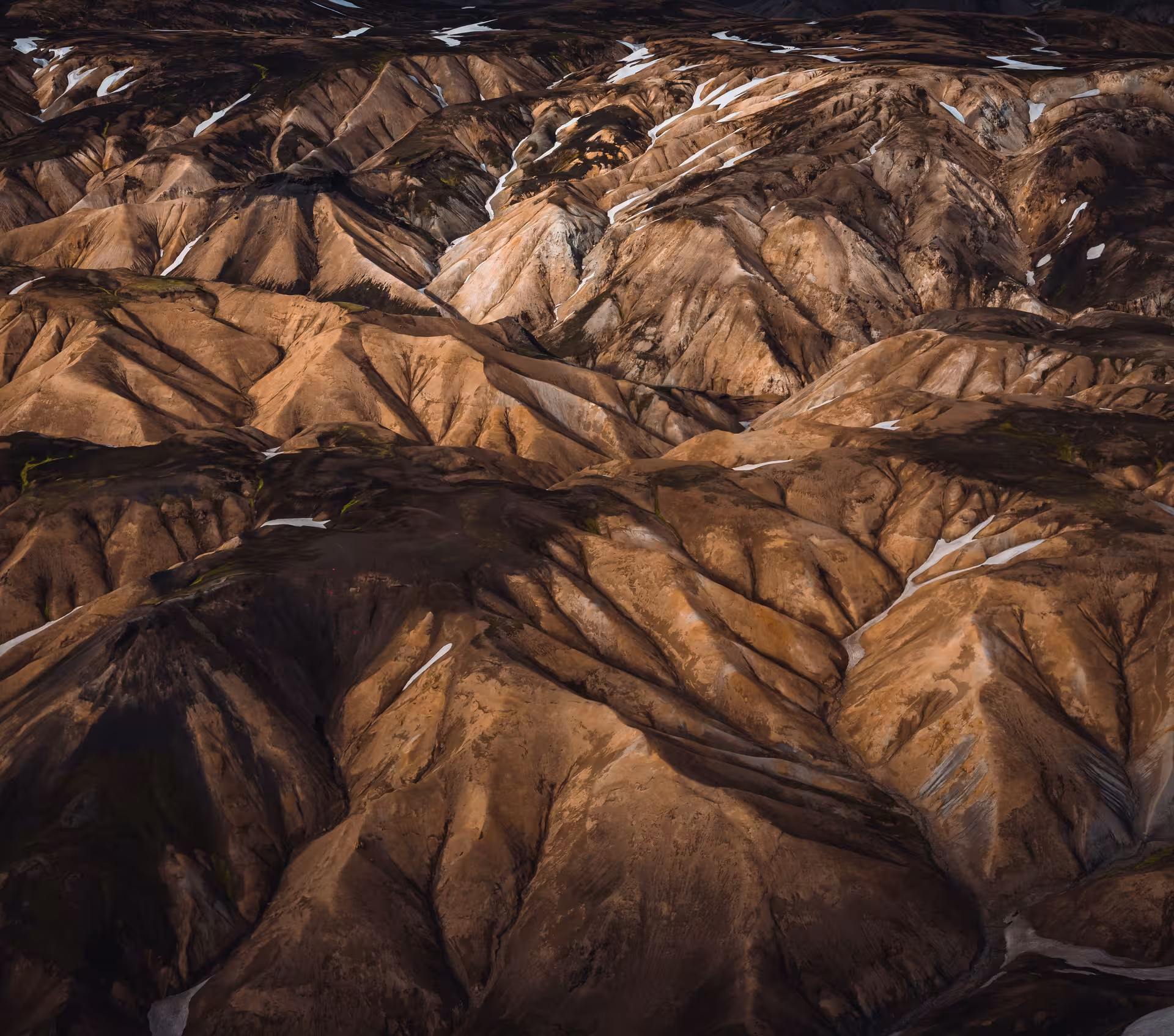 Aerial view of Landmannalaugar rhyolite mountains with snow patches from helicopter tour Iceland