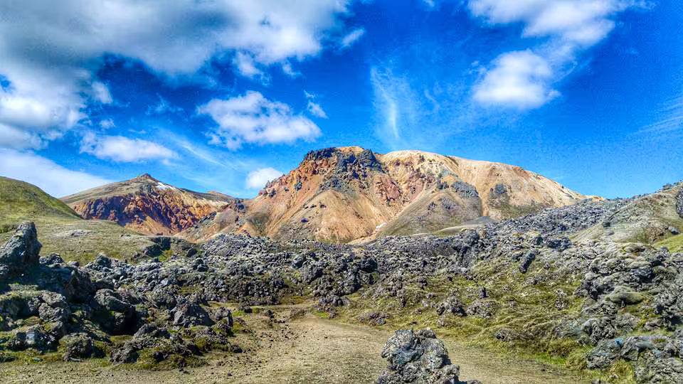 Colorful rhyolite mountains and lava fields under blue sky at Landmannalaugar Iceland