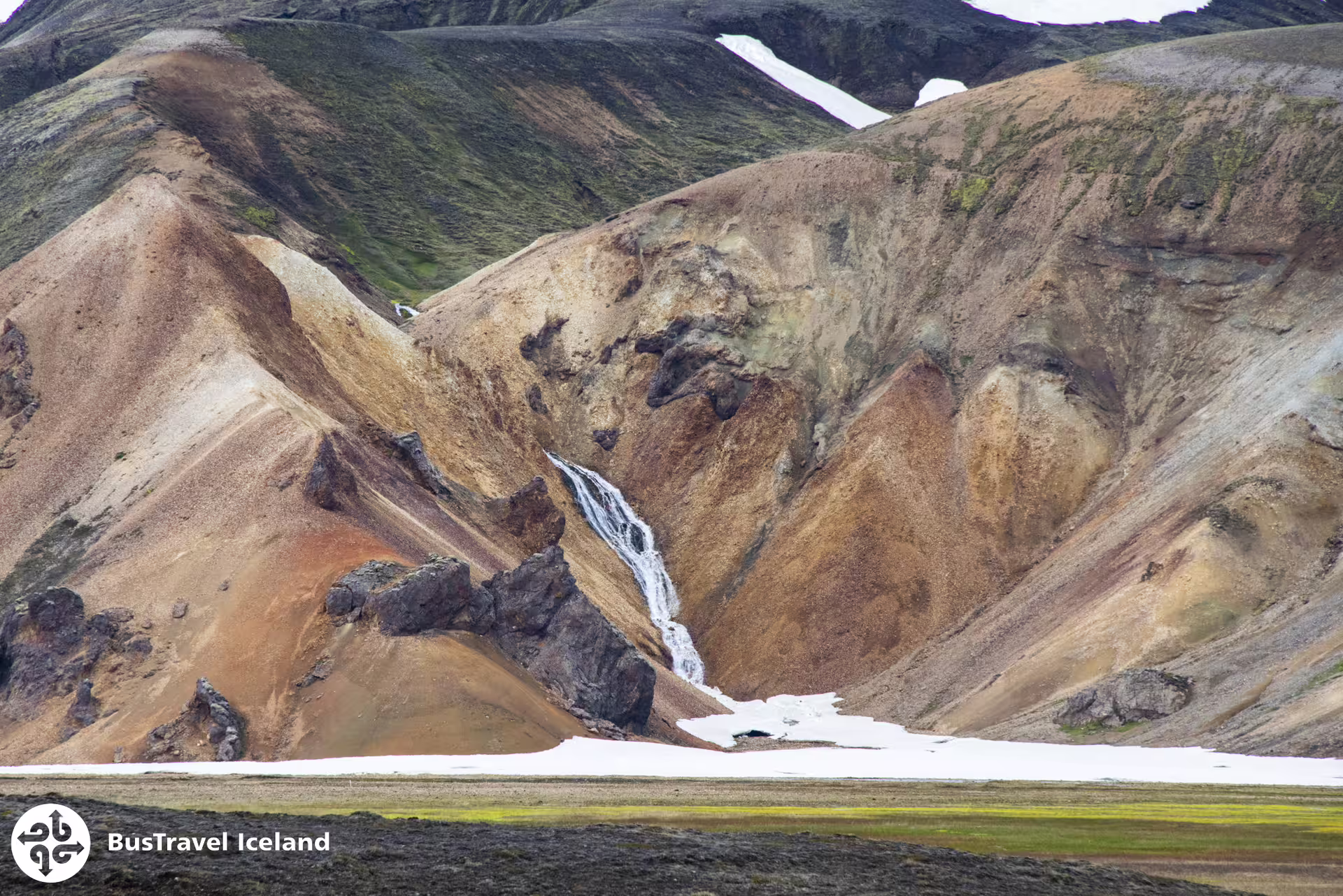 Colorful rhyolite mountains with waterfall and snow at Landmannalaugar highlands, Iceland