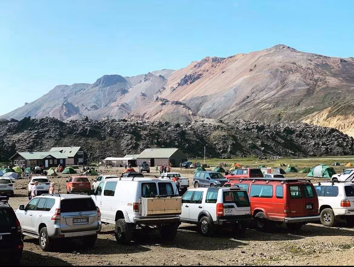 Super jeep vehicles parked at Landmannalaugar campsite with colorful rhyolite mountains in Iceland