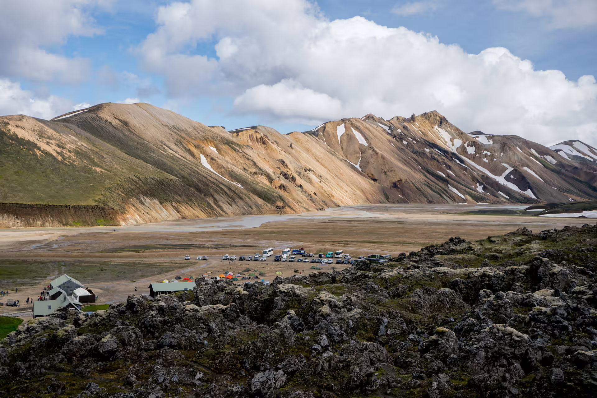 Panoramic view of Landmannalaugar highland camp with colorful rhyolite mountains and lava field in Iceland