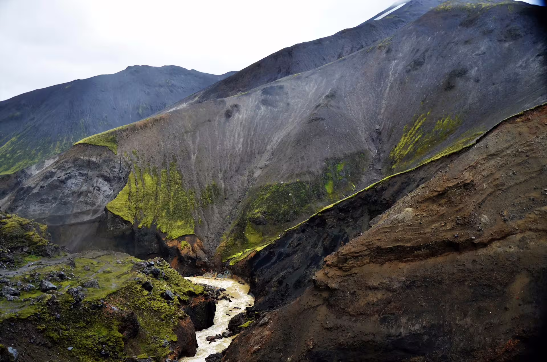Rugged volcanic canyon with rushing geothermal river and moss-covered cliffs in Landmannalaugar Iceland jeep tour