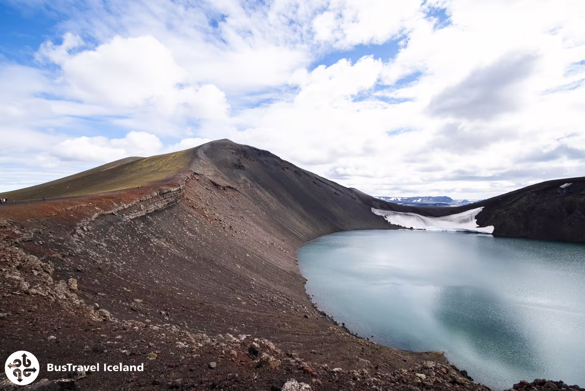 Volcanic crater lake with turquoise water and dark lava slopes at Landmannalaugar, Iceland