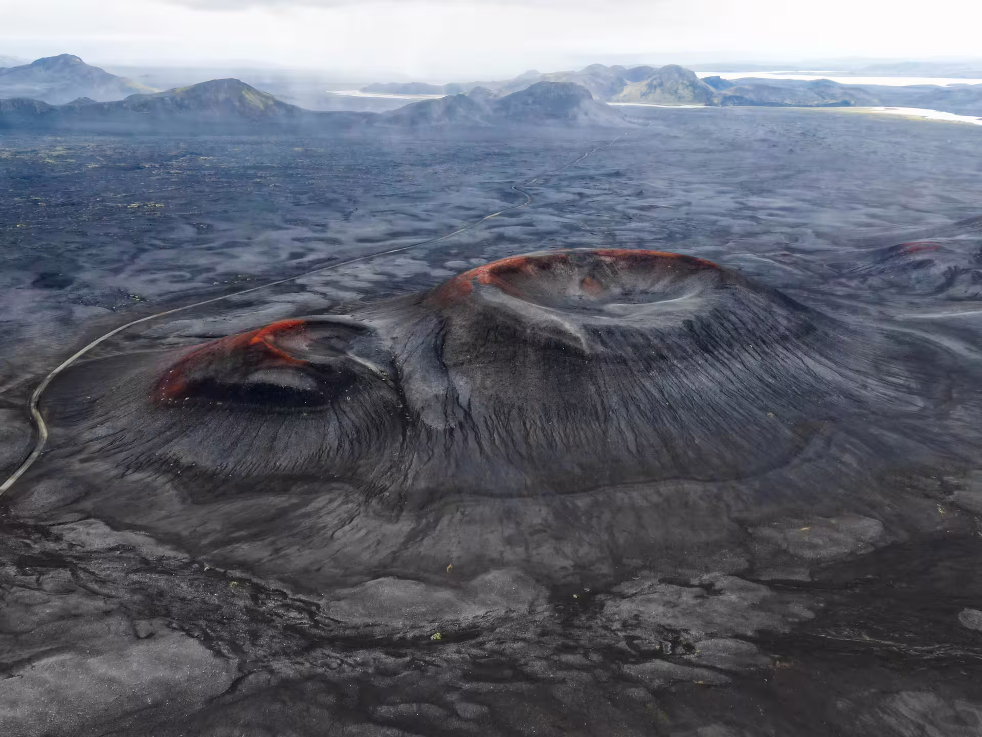 Aerial view of dramatic volcanic craters with red lava rims on Iceland's black lava highlands near Landmannalaugar super jeep transfer route