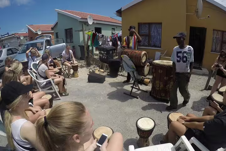 Tourists enjoying a vibrant drumming session in Langa Township during the half-day culinary and cultural tour.