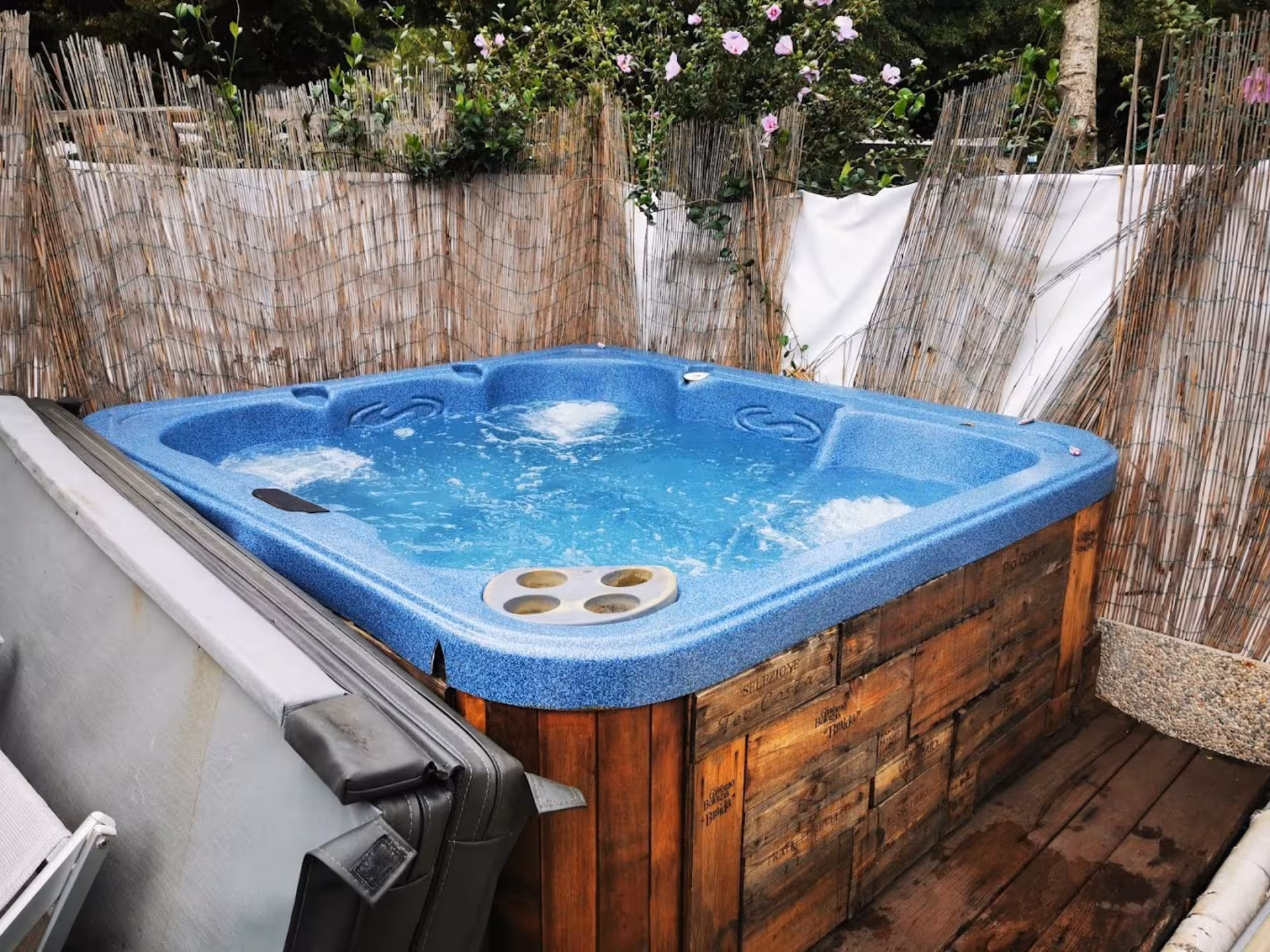 Inviting outdoor hot tub at Langhe Spa, surrounded by rustic wooden panels and greenery for a relaxing wellness escape.