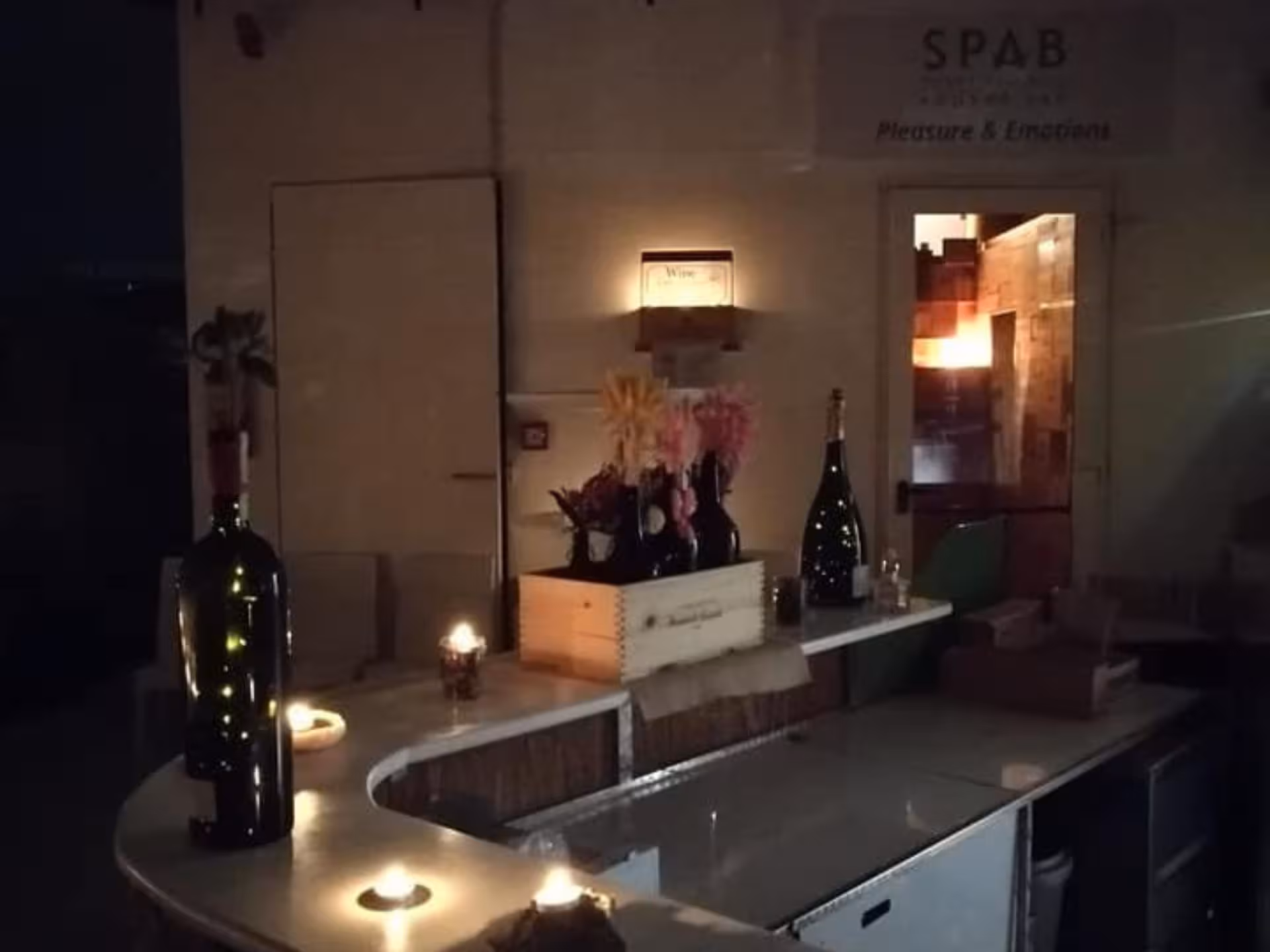 Cozy Langhe spa bar with ambient candlelight and wine bottles creating a serene wellness experience.