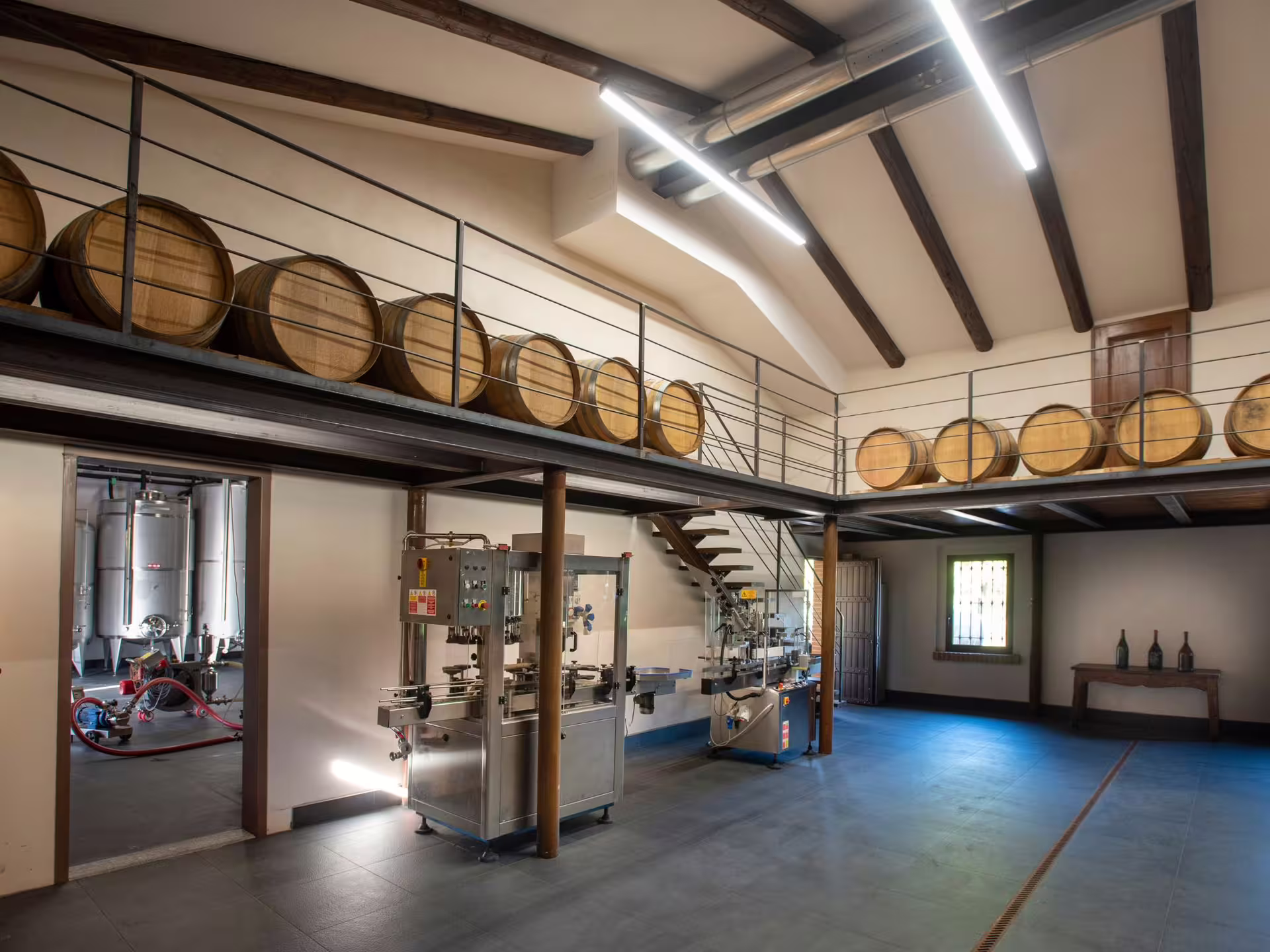Interior of a Langhe winery showcasing wooden barrels and modern equipment, perfect for wine tasting experiences.