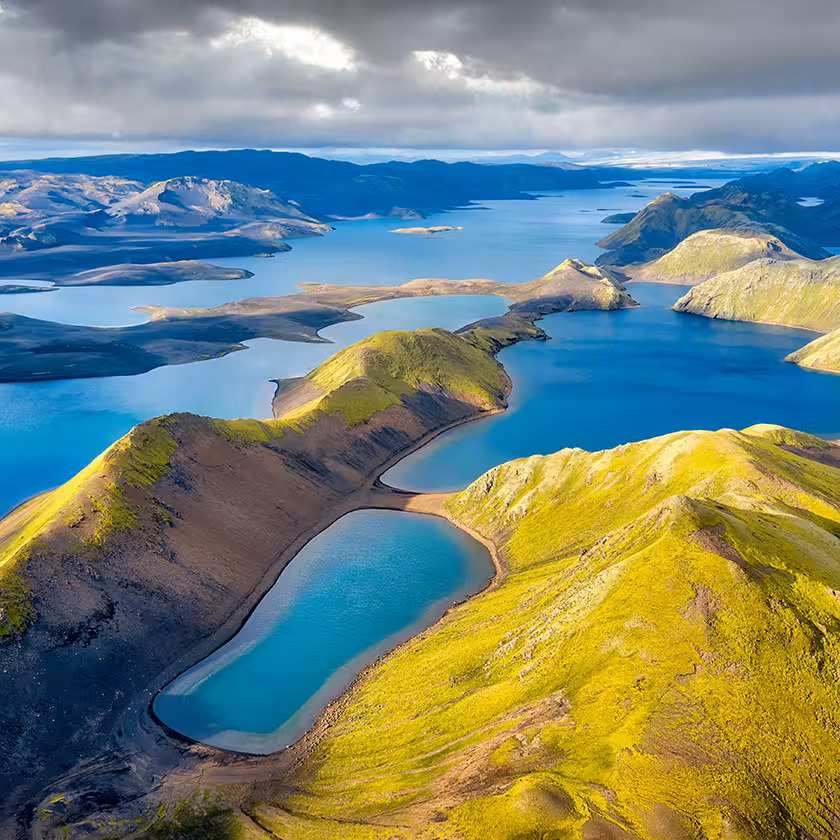 Aerial view of Langisjor Lake surrounded by green volcanic mountains and vivid blue waters in Iceland's highlands