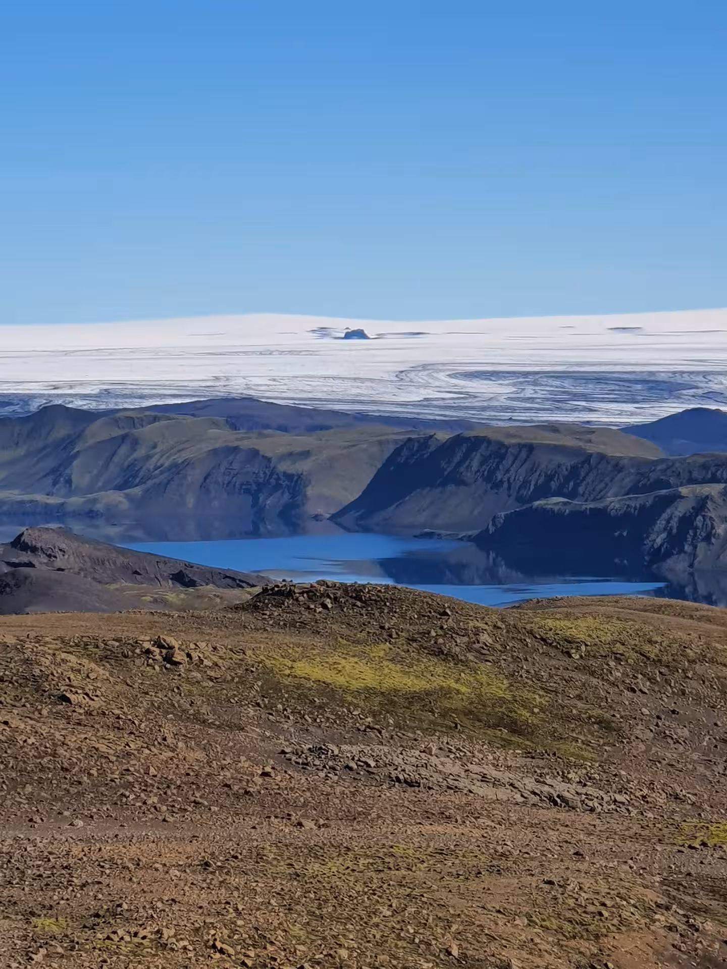 Langisjor Lake surrounded by volcanic mountains with Vatnajokull glacier in the background, Iceland