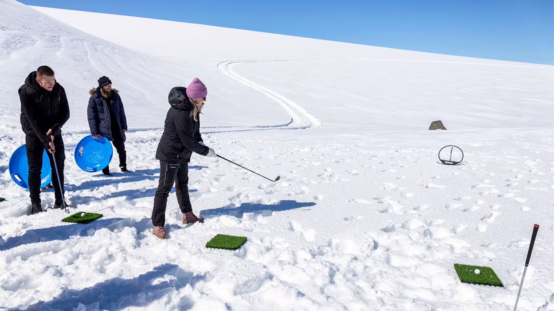 Guests play snow golf on Langjökull Glacier during Summer Solstice tour from Gullfoss in Iceland