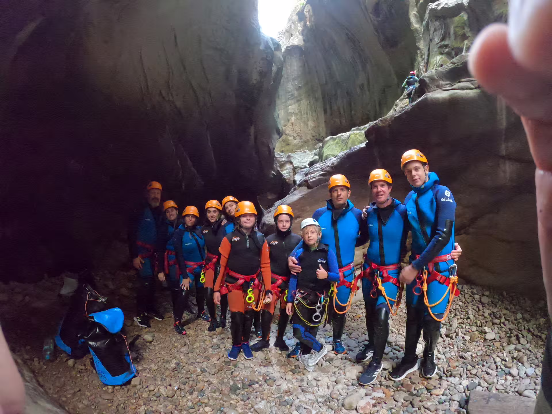 Group of canyoneers in wetsuits and helmets posing inside Las Buitreras Canyon narrow gorge Málaga Province