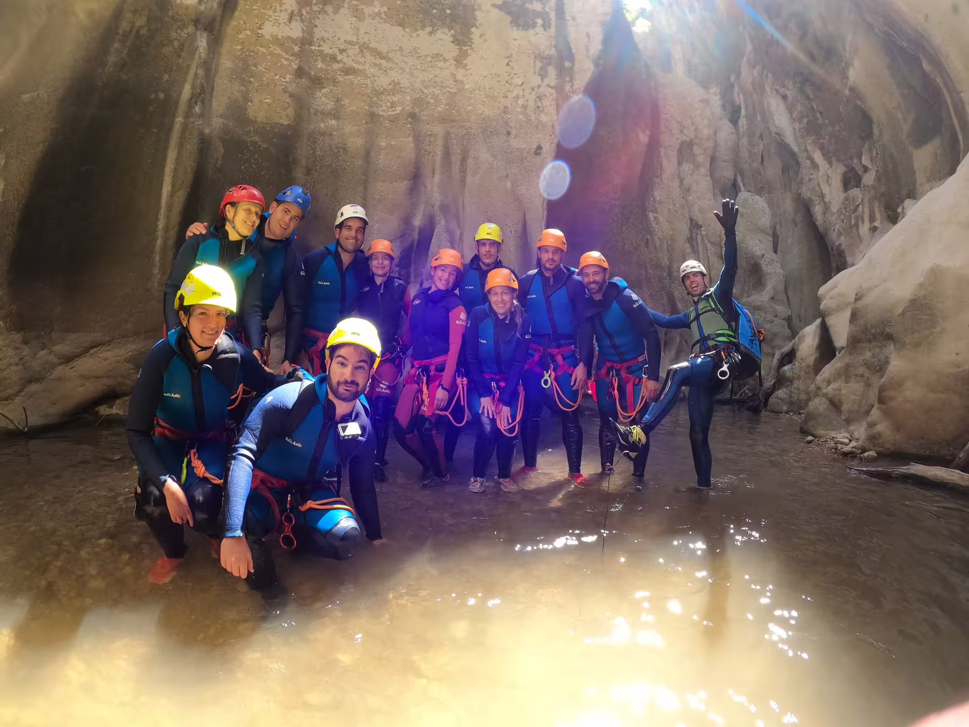 Guided canyoning group in wetsuits and helmets posing inside Las Buitreras Canyon narrow gorge Málaga