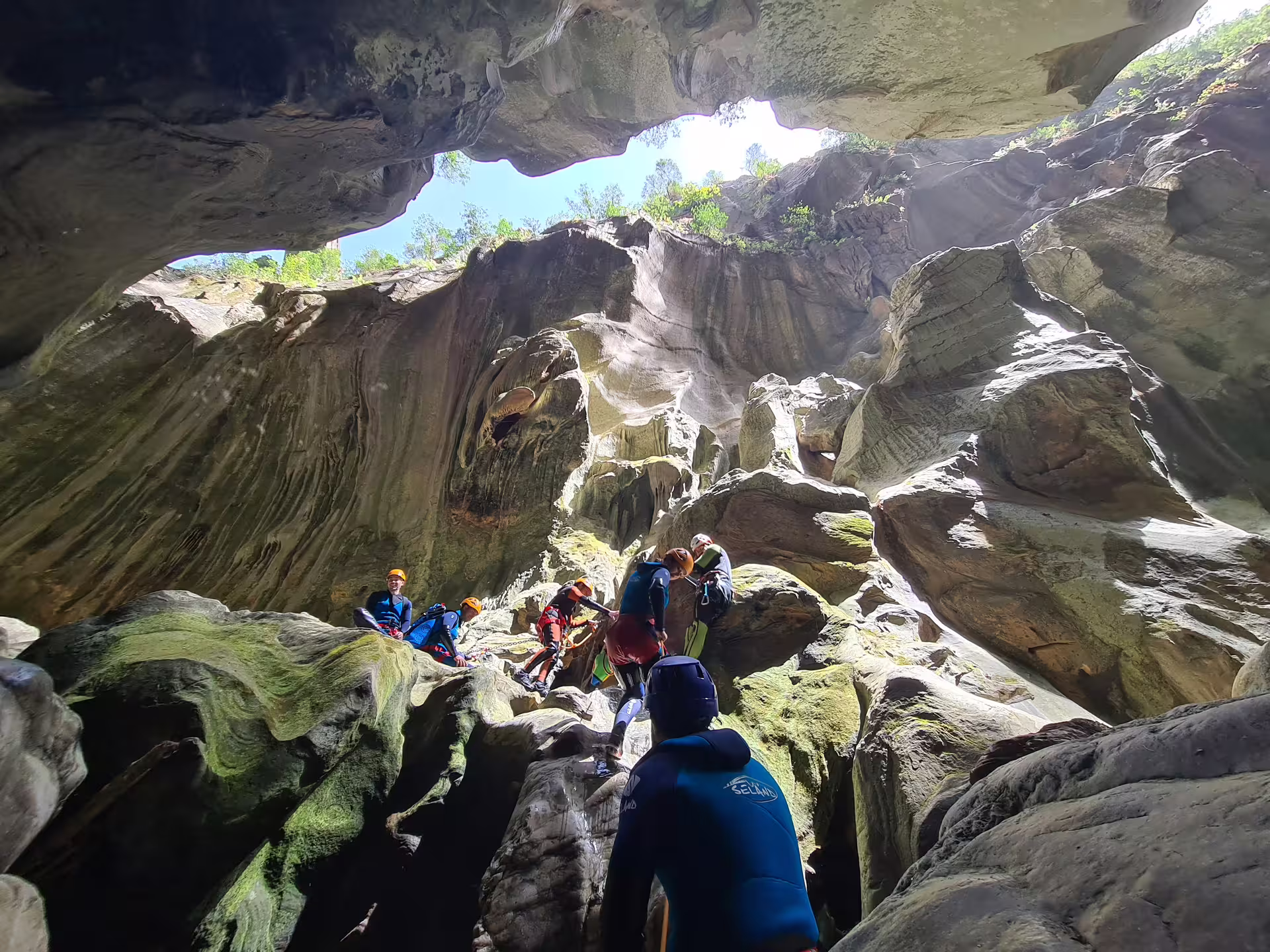 Canyoning tour group navigating dramatic sculpted rock formations inside Las Buitreras Canyon Málaga Spain
