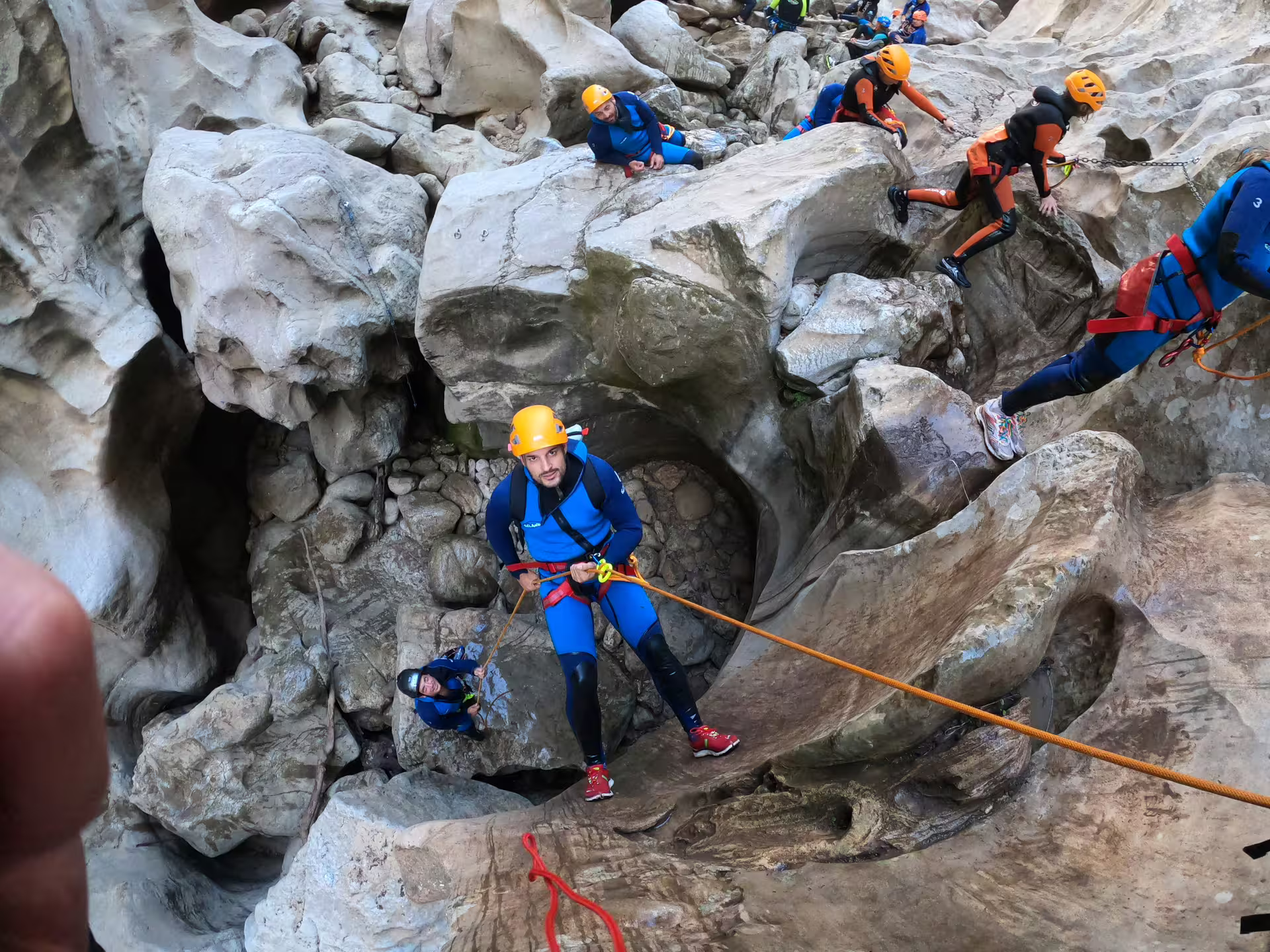 Guided canyoning group rappelling down dramatic rock formations in Las Buitreras Canyon Málaga Province Spain