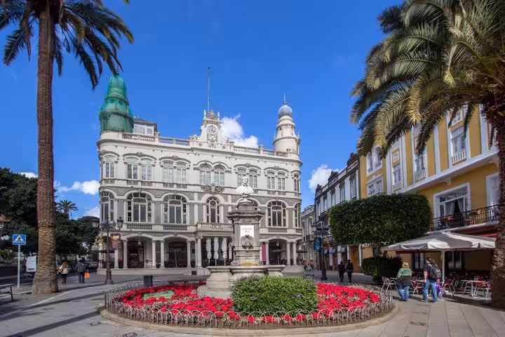 Plaza de Cairasco with ornate white colonial building, fountain, and red flowers in Las Palmas, Gran Canaria
