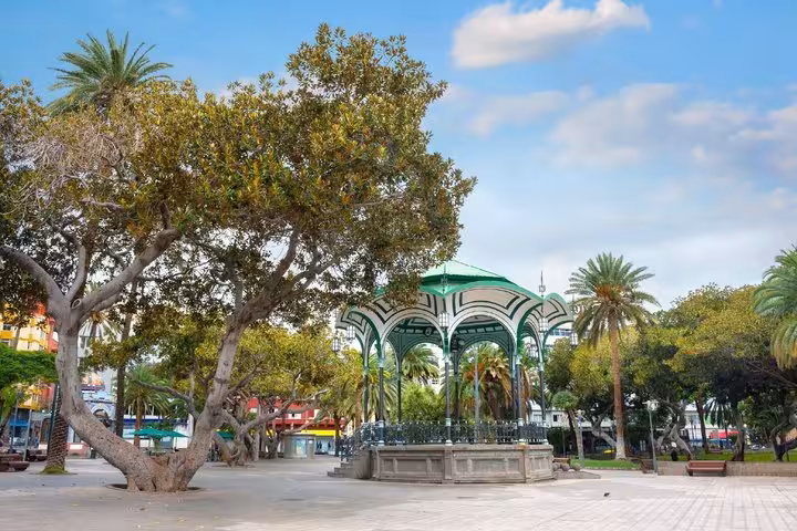 Green ornate gazebo kiosk in a tree-lined plaza in Las Palmas, Gran Canaria
