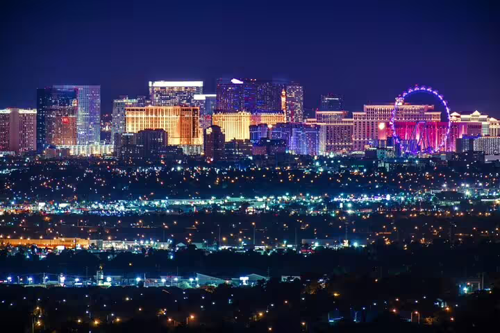 Las Vegas Strip skyline at night with glowing casino lights and High Roller Ferris wheel
