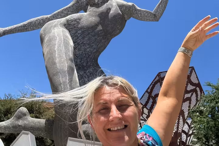 Smiling woman posing in front of large wire mesh sculpture on the Las Vegas Strip